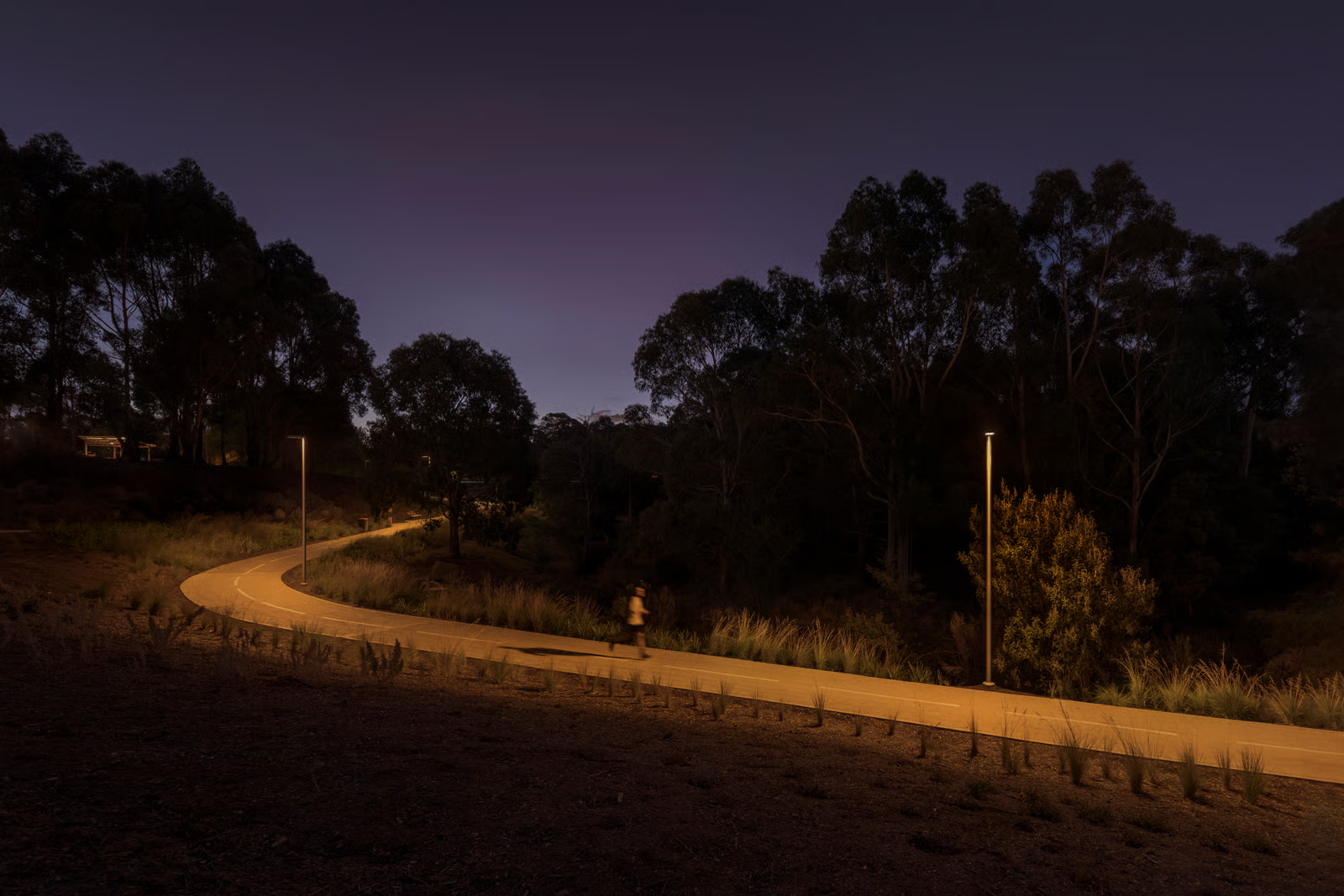 Motion-blurred walker on Kingston Parklands Creek Pathway illuminated by groundbreaking 2200K WE-EF VFL530 LED luminaires creating warm amber pathway lighting, native Tasmanian grasslands and eucalyptus forest flanking path, demonstrating Kingborough Council's wildlife protection approach praised as 'groundbreaking step forward for protection of darkness and wildlife' by Environment Head Liz Quinn, completed 2022 on sustainable recreational space