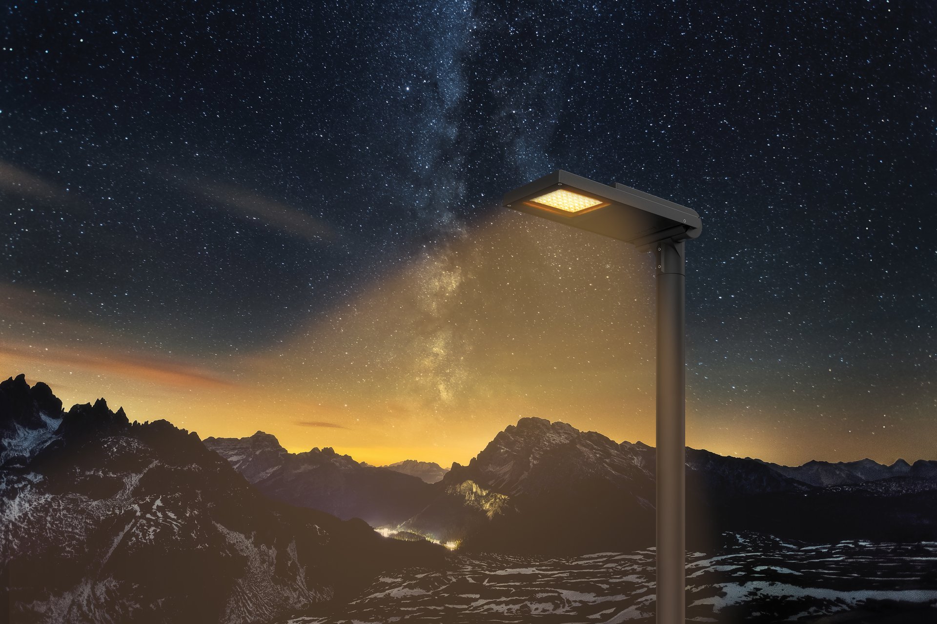 A photo collage featuring the AFL100 street luminaire with its lights on, set against a stunning mountain landscape under a starry night sky.