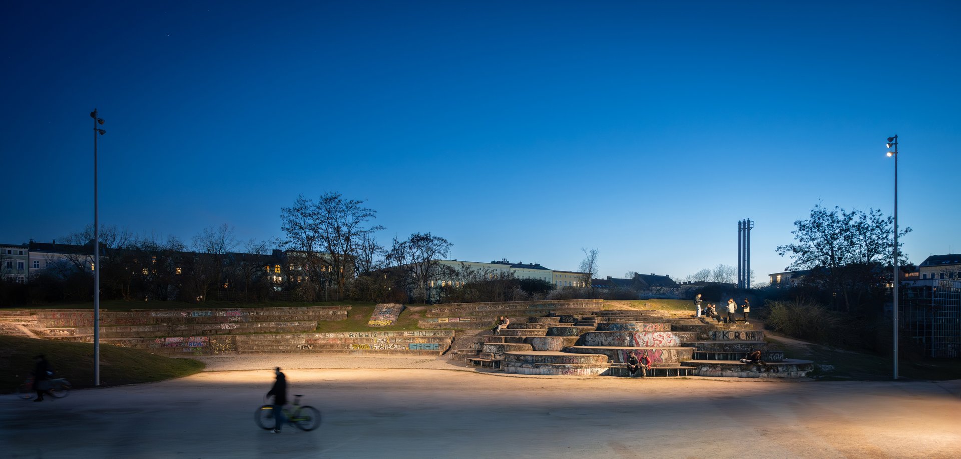 Illuminated open space in Berlin’s Görlitzer Park at night, featuring stepped seating, precise light distribution and enhanced visual comfort.