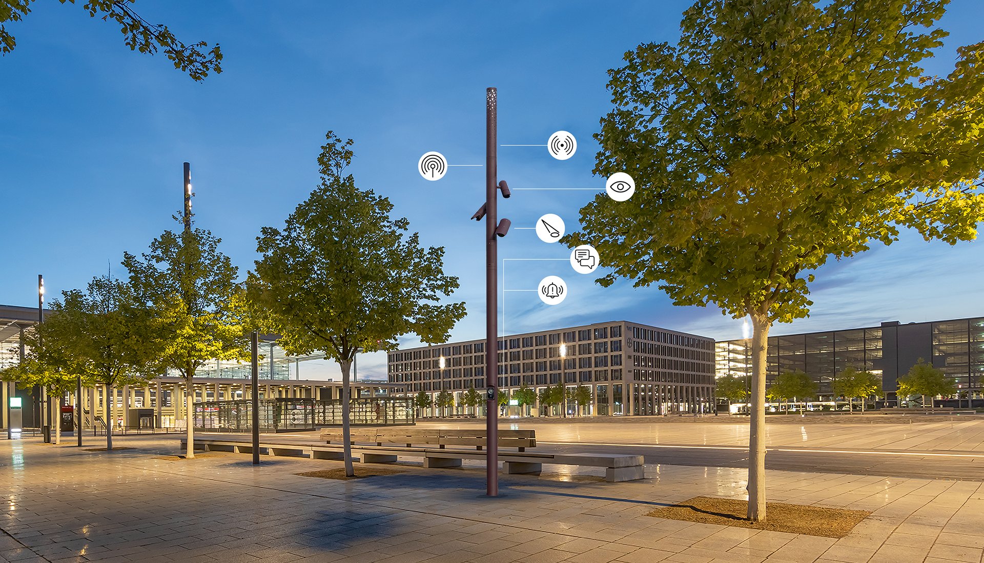 Smart city lighting pole with integrated digital technologies, sensors and communication systems in an urban plaza at dusk.