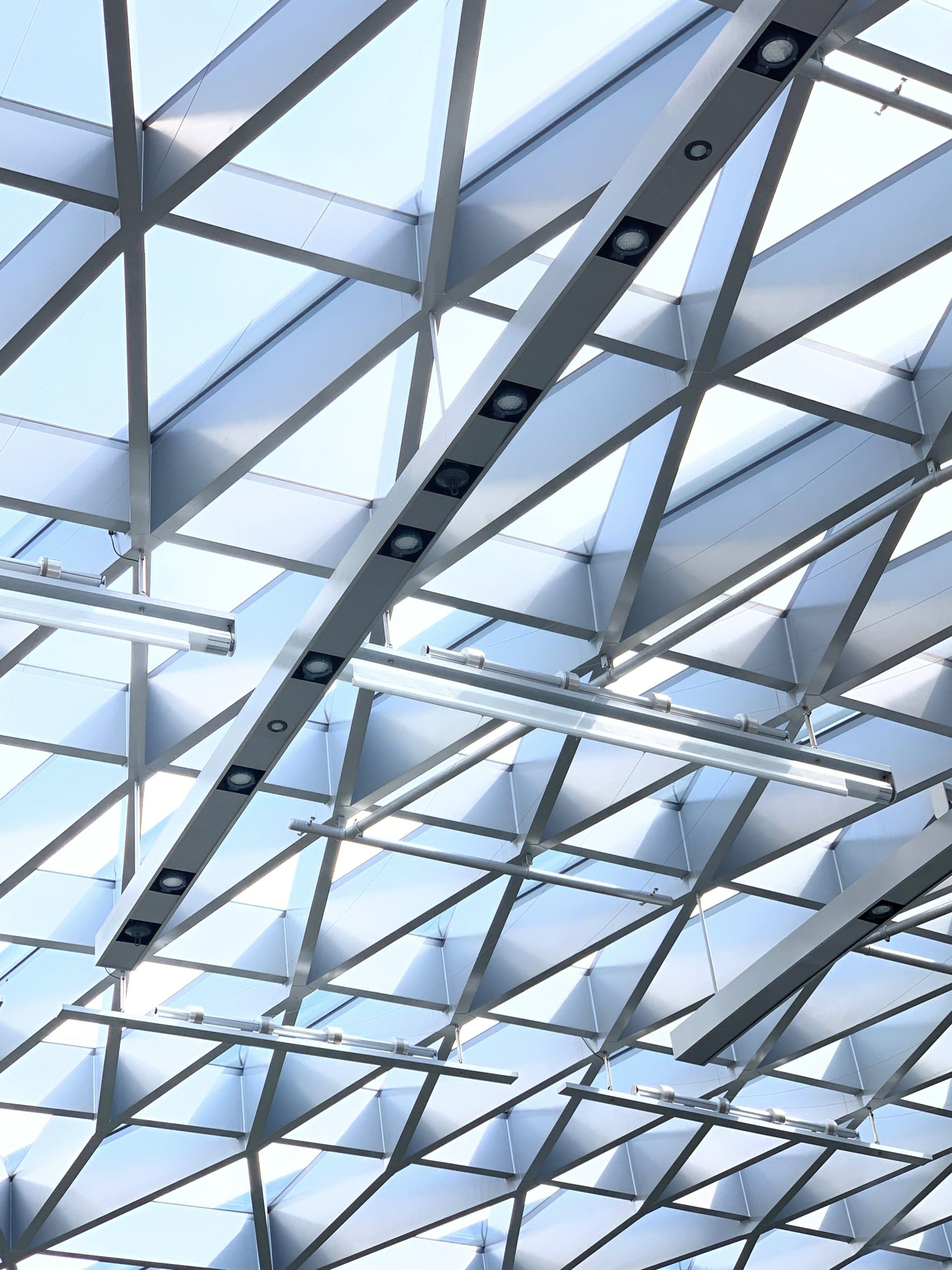 WE-EF FLC121 and FLC141 projectors with glare shields integrated into steel structure illuminating geodesic glass dome at Jewel Changi Airport Singapore