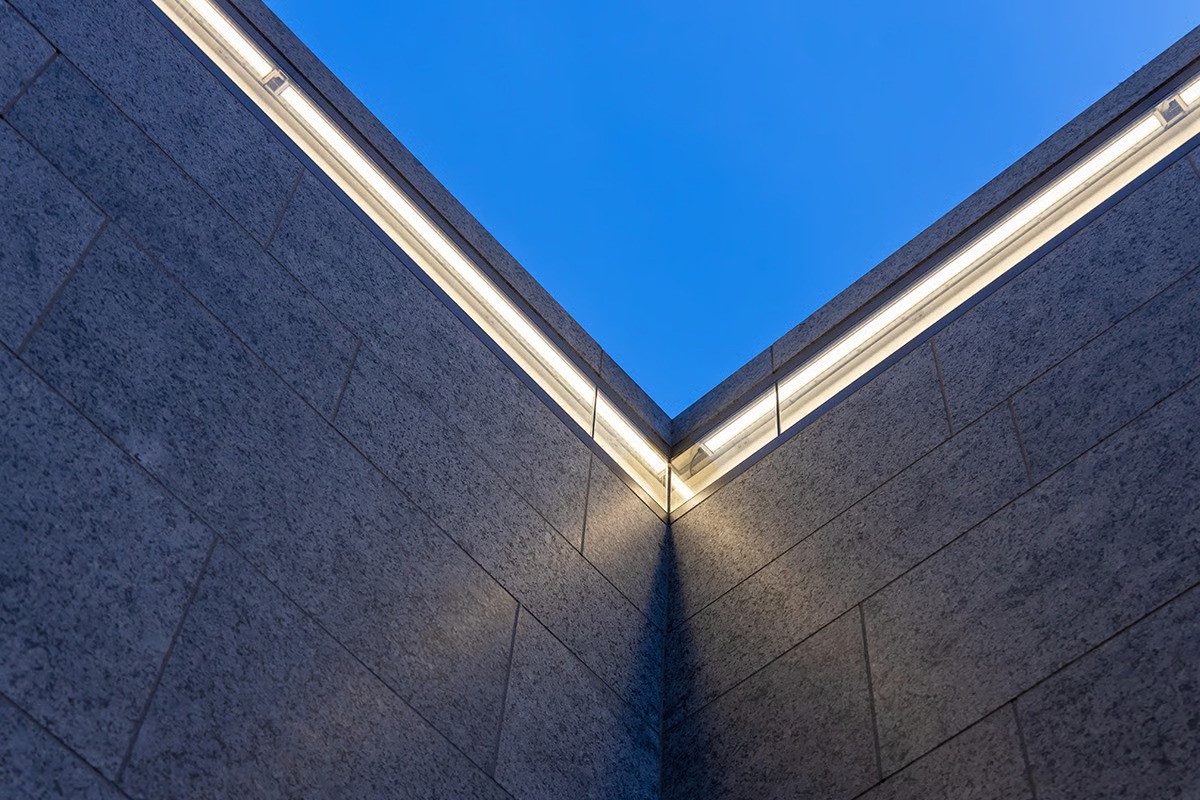 Architectural detail of Museumsinsel station's arched platform tunnel showing integration of WE-EF DOC220 recessed ceiling luminaires positioned asymmetrically in curved vault structure, brilliant starlight points against ultramarine blue background creating immersive theatrical atmosphere inspired by Schinkel's historic stage design, demonstrating how functional platform lighting supports dramatic decorative concept in Berlin's newest U5 station serving Museum Island UNESCO World Heritage Site