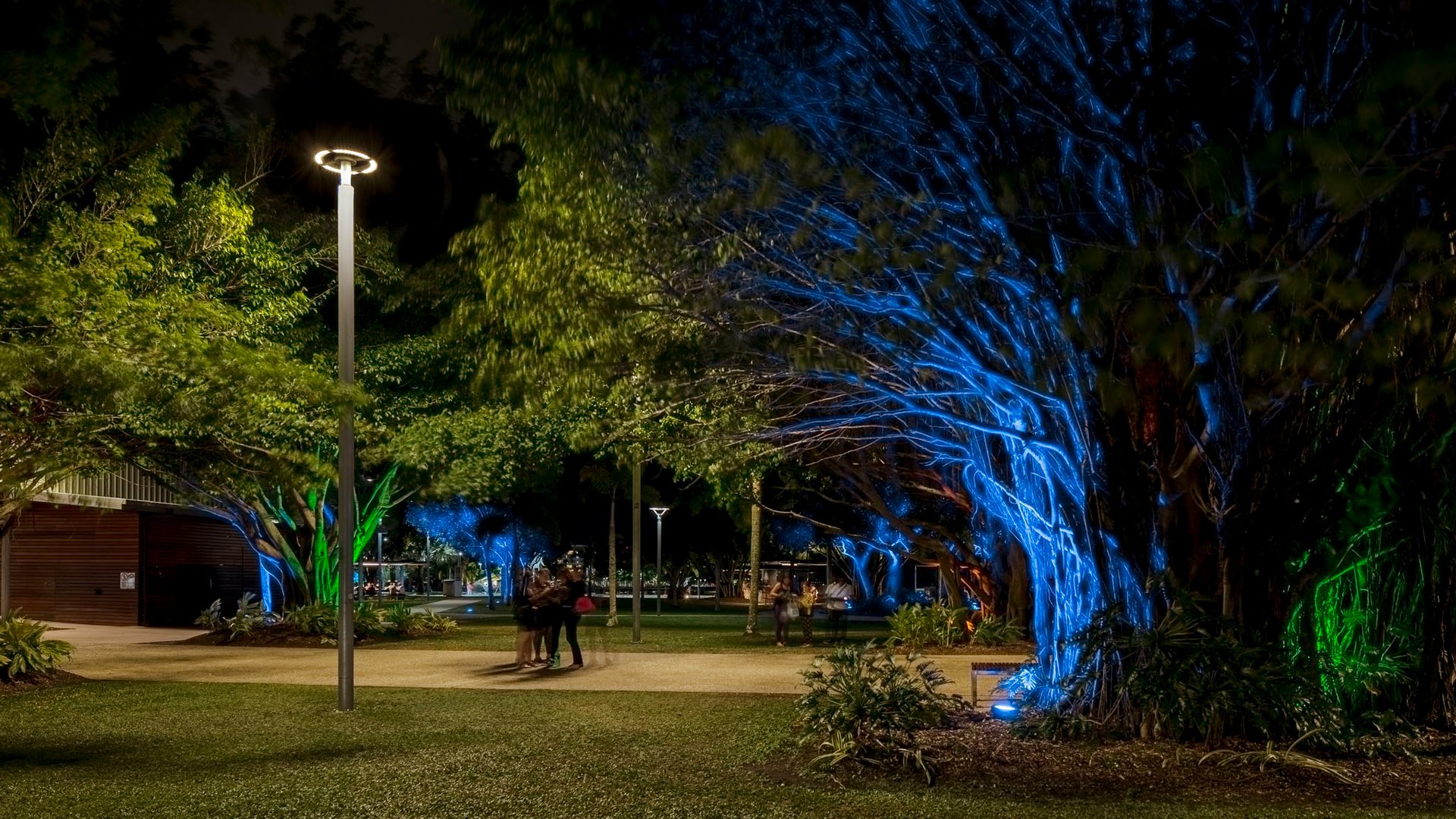 Public open space at twilight showing balanced lighting design approach with functional pathway illumination and preserved natural darkness zones, demonstrating contemporary understanding that brighter does not equal safer, emphasizing quality layered lighting with warm color temperatures, vertical and horizontal illumination, and environmental sensitivity meeting Australian standards AS1158 and AS4282 for external and obtrusive lighting