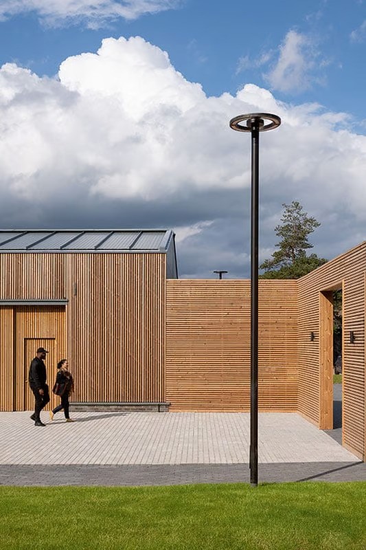 Detail of WE-EF CFT540 ring-shaped LED pole-mounted luminaire on 5-meter aluminum pole at Croxley Park showing clear modern design language, innovative OLC One LED Concept multi-layer lens technology with RFC reflector cover technology using UV-stabilized contour cover reducing internal reflection to absolute minimum for improved efficiency, warm white 3000K LED providing uniform light distribution with very good visual comfort, durable energy-efficient product supporting ambitious sustainability goals while serving as defining architectural feature of office park designed by ESA architects London