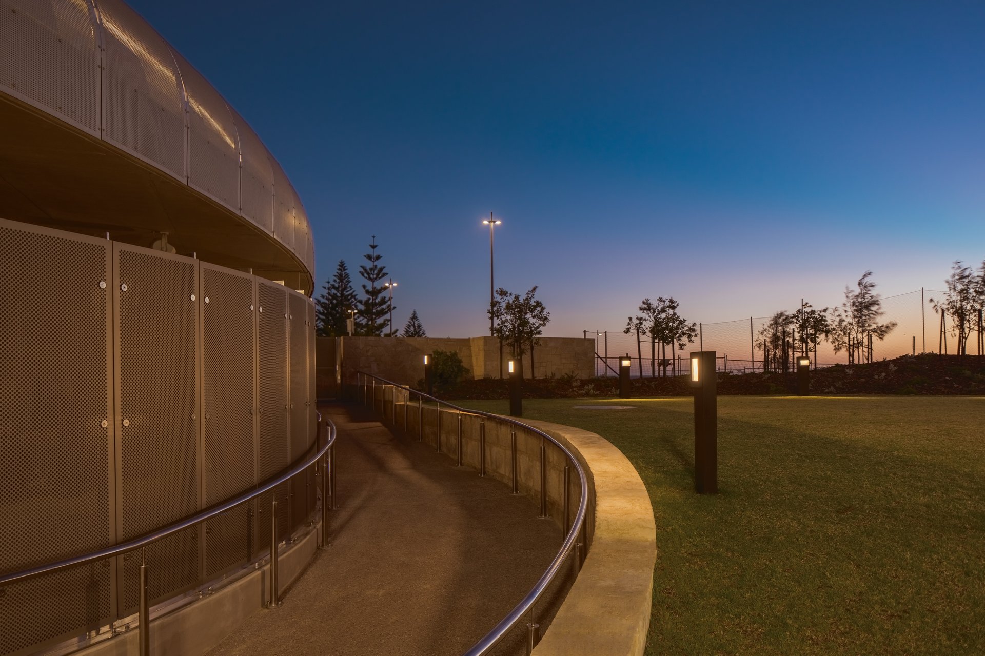 WE-EF RFL530-SE street lighting and bollards illuminating curved pathway at dusk with digital dimming control at Scarborough Beach Pool IESANZ award-winning project