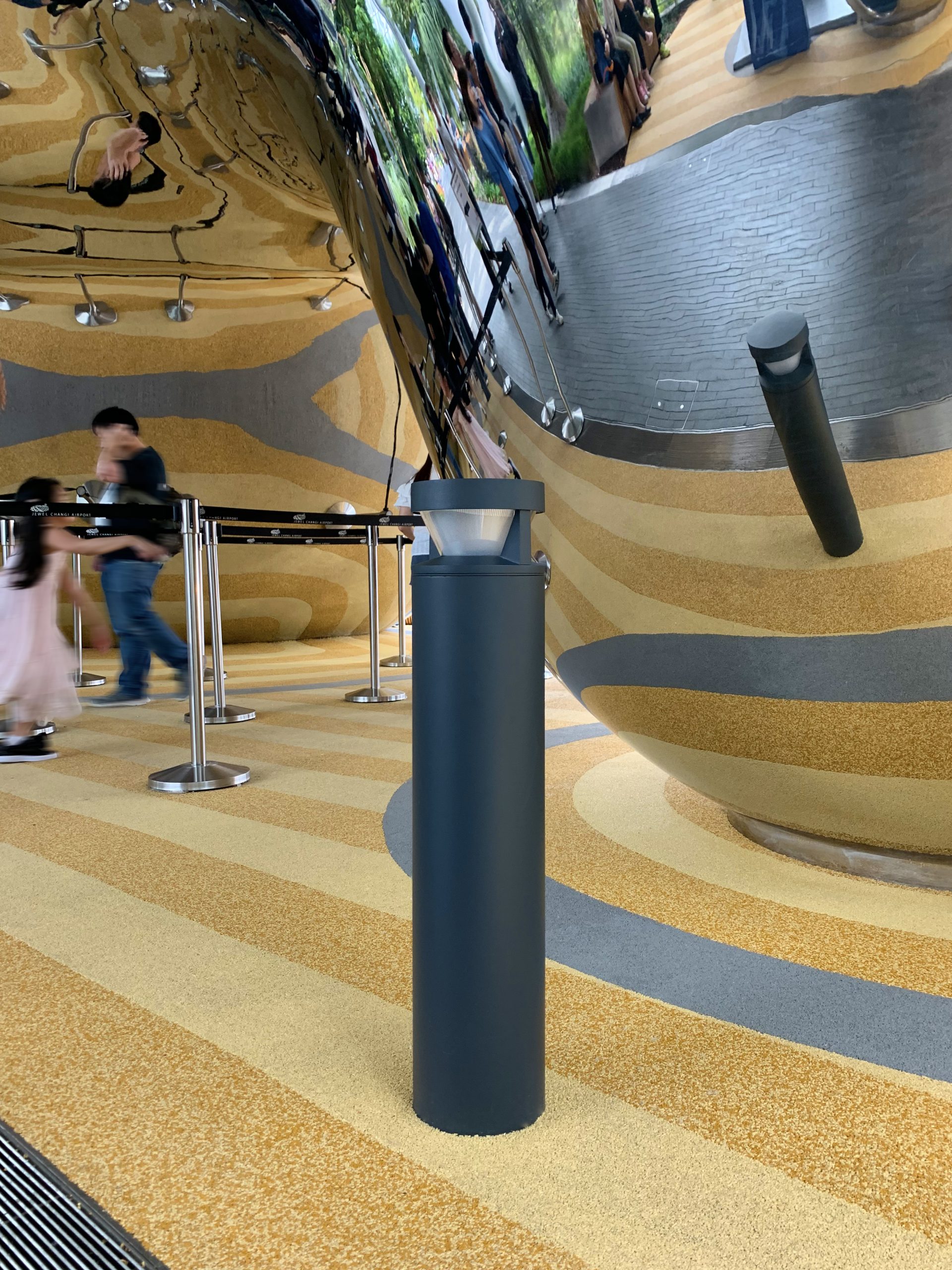 WE-EF bollard luminaires providing glare-free pathway lighting at Jewel Changi Airport terminal with visitors and Rain Vortex waterfall visible in background Singapore