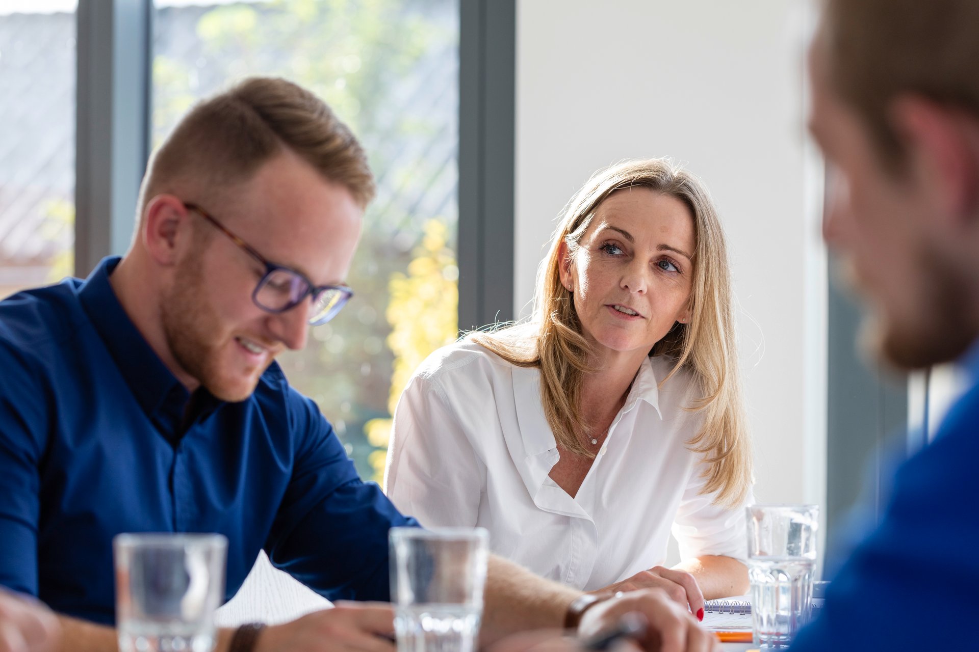 WE-EF employees in a modern office discussing concepts and listening to each other