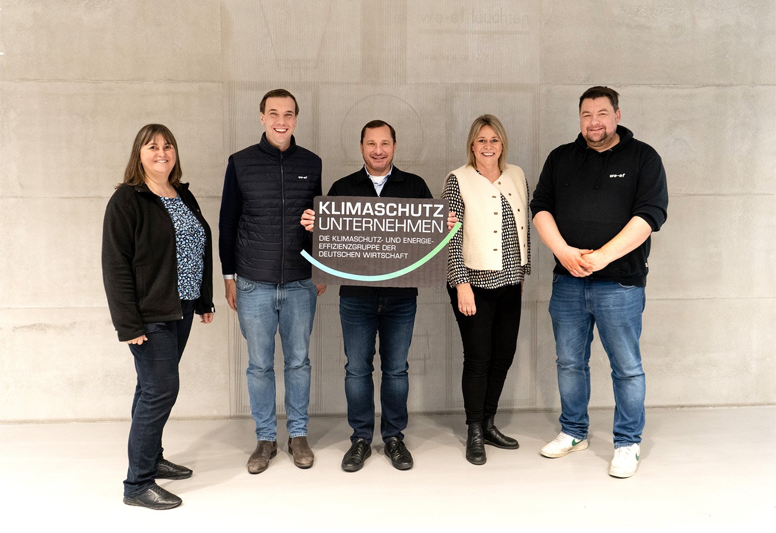 WE-EF CEO Thiemo Cordes and team members proudly hold the official recognition plaque from the "Klimaschutz Unternehmen" association, celebrating this important milestone on WE-EF’s journey toward a carbon-neutral future.
